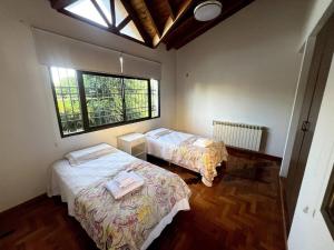 een slaapkamer met 2 bedden en een raam bij Casa Nervo in Guaymallen
