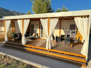 a wooden deck with white curtains on it at Ayana Mobile Home in Orebić