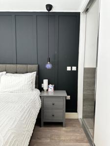 a bedroom with a bed and a table with a lamp at Stylish Apartment City Centre in Sheffield