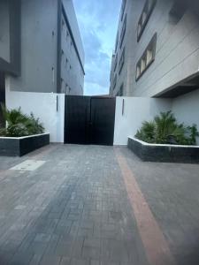 a parking lot with a black gate between two buildings at Jamal Royal Apartments in Medina