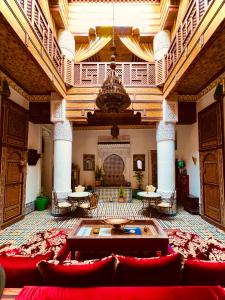 Habitación grande con sofás rojos y mesas en un edificio en Ryad Zahrat Fes en Fez