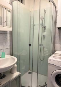 y baño con ducha acristalada y lavamanos. en Zum Breyer BNB City Apartment, en Baden