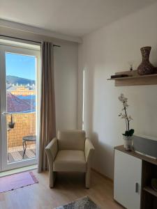 a living room with a chair and a window at Zum Breyer BNB City Apartment in Baden