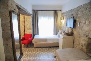 a hotel room with a bed and a red chair at Filizce Alaçatı in İzmir