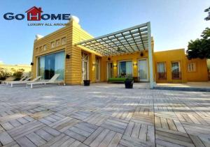 - un bâtiment jaune avec une terrasse en face dans l'établissement Stylish 5B Room MB04 at New Marina, à Hurghada