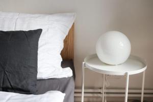 a table next to a bed with a white orb on it at Ubytovanie v Kláštore - Apartmány in Rožňava