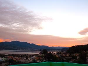 a view of a city and a lake at sunset at Green House Araque Inn in Otavalo