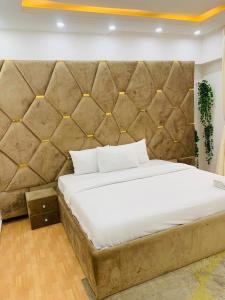 a bedroom with a large bed with a large headboard at Emray Shortlets apartment in Lekki