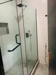 a shower with a glass door in a bathroom at Emray Shortlets apartment in Lekki