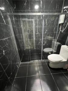 a bathroom with a toilet and a black tiled wall at Red sophia suites in Istanbul