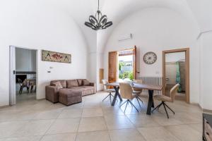 a living room with a table and a couch at Bovio28 - Nel Centro Del Salento in Carmiano