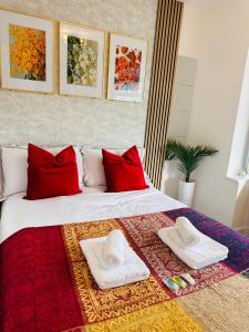 duże łóżko z czerwonymi poduszkami i ręcznikami w obiekcie R-1 Newly renovated En-Suite Self contained Private Room in Selly Oak Birmingham w Birmingham