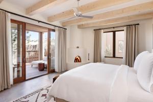 een slaapkamer met een wit bed en een open haard bij Four Seasons Resort Rancho Encantado Santa Fe in Santa Fe