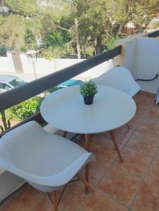 três mesas brancas e um vaso de plantas numa varanda em Formentera Suite 10 em Es Pujols