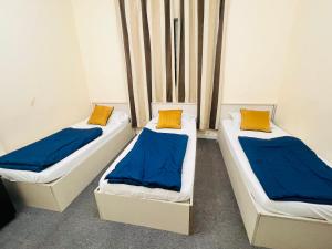 two beds in a room with blue and yellow pillows at Short Term Tourist Place in Dubai