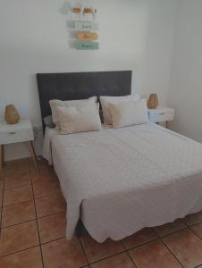 um quarto com uma cama grande e 2 mesas brancas em Formentera Suite 10 em Es Pujols