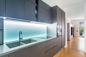 a kitchen with blue cabinets and a sink at Appartamento Peschiera Borromeo - Linate in Peschiera Borromeo +8 photos