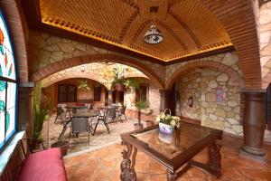 eine überdachte Terrasse mit Tisch und Stühlen in einem Gebäude in der Unterkunft Hotel Santa Irene in Cholula de Rivadavia