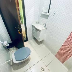 a bathroom with a blue toilet and a sink at Chácara Li&Mazinho in Ibiúna +4 photos