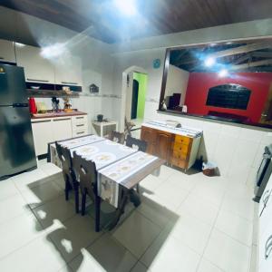 a large kitchen with a table and a refrigerator at Chácara Li&Mazinho in Ibiúna