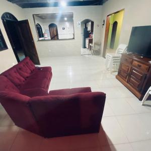 a living room with a couch and a flat screen tv at Chácara Li&Mazinho in Ibiúna
