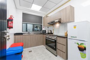 a kitchen with a refrigerator and a stove top oven at Luxury Hotel Apartment Mall of Emirates in Dubai