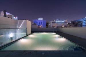 a swimming pool on the roof of a building at night at Luxury Hotel Apartment Mall of Emirates in Dubai