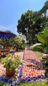 a garden with a brick pathway with a table and chairs at Hotel Casa Oliveros in Rivera