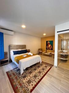 a bedroom with a large bed and a bathroom at Hotel Casa Oliveros in Rivera