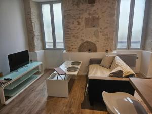 a living room with a couch and a tv at Appartement centre historique d'Auch in Auch +1 photo