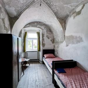 a bedroom with two beds and a window at Ubytovanie v Kláštore - Hostel in Rožňava