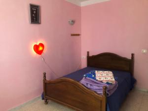 1 dormitorio con 1 cama con un globo cardíaco rojo en Villa Neji, Havre de pierre à 10 min de la plage. en Korba