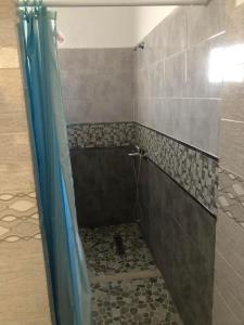 łazienka z prysznicem z niebieską zasłoną prysznicową w obiekcie Villa Neji, Havre de pierre à 10 min de la plage. w mieście Korba