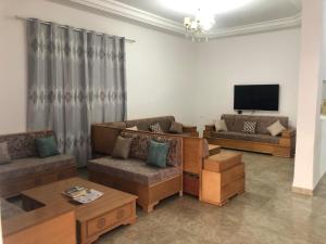 a living room with couches and a flat screen tv at Villa Neji, Havre de pierre à 10 min de la plage. in Korba