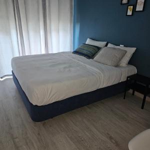 Una cama con sábanas blancas y almohadas en un dormitorio en Marinha Garden Inn en Marinha Grande