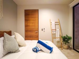 a bedroom with a white bed with a wooden door at Akua Tulum Mexico in Tulum