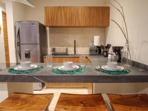 a kitchen with two plates and cups on a counter at Akua Tulum Mexico in Tulum