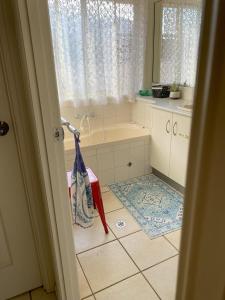 een badkamer met een bad, een wastafel en een bad bij Red Cottage. 2 ROOM FOR 1. BEDROOM+Private Kithenette, Lounge, TV, Fridge room in Harristown