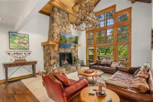a living room with a stone fireplace and leather furniture at The 17th hole in Cle Elum