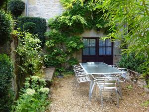 a table and chairs in front of a building at La Familiale, Aile du Château de Busqueilles à Autoire, 3 chambres, 3 SDB, vue parc & calme in Autoire +13 photos