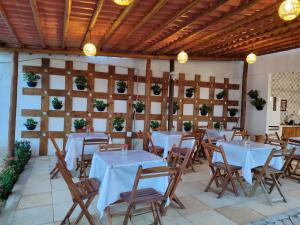 um restaurante com mesas brancas e tectos em madeira em La Belle de Jour em Majorlândia