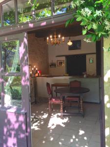 une terrasse avec une table, des chaises et une télévision dans l'établissement Château de Busqueilles - La Couple, à Autoire