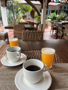 a cup of coffee and two glasses of orange juice on a table at Hotel Casa Oliveros in Rivera