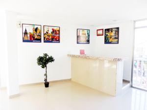 a white room with a counter with pictures on the wall at Limsor Aphotel in San Andrés