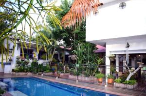 a pool in front of a house with plants at Hotel Casa Oliveros in Rivera