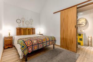 a bedroom with a bed with a colorful bedspread at Casa dos Bardos in Alvações do Corgo +26 photos