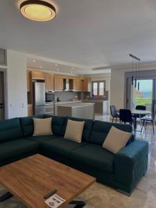 a living room with a green couch and a kitchen at Acqua Blu Blu apartment in Koroni