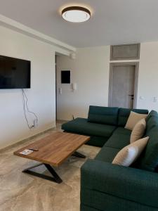 a living room with a green couch and a coffee table at Acqua Blu Blu apartment in Koroni