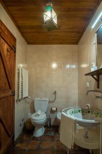 a bathroom with a toilet and a tub and a sink at Quinta do Brejo - Turismo Equestre in Mafra