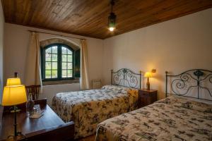 a bedroom with two beds and a window at Quinta do Brejo - Turismo Equestre in Mafra